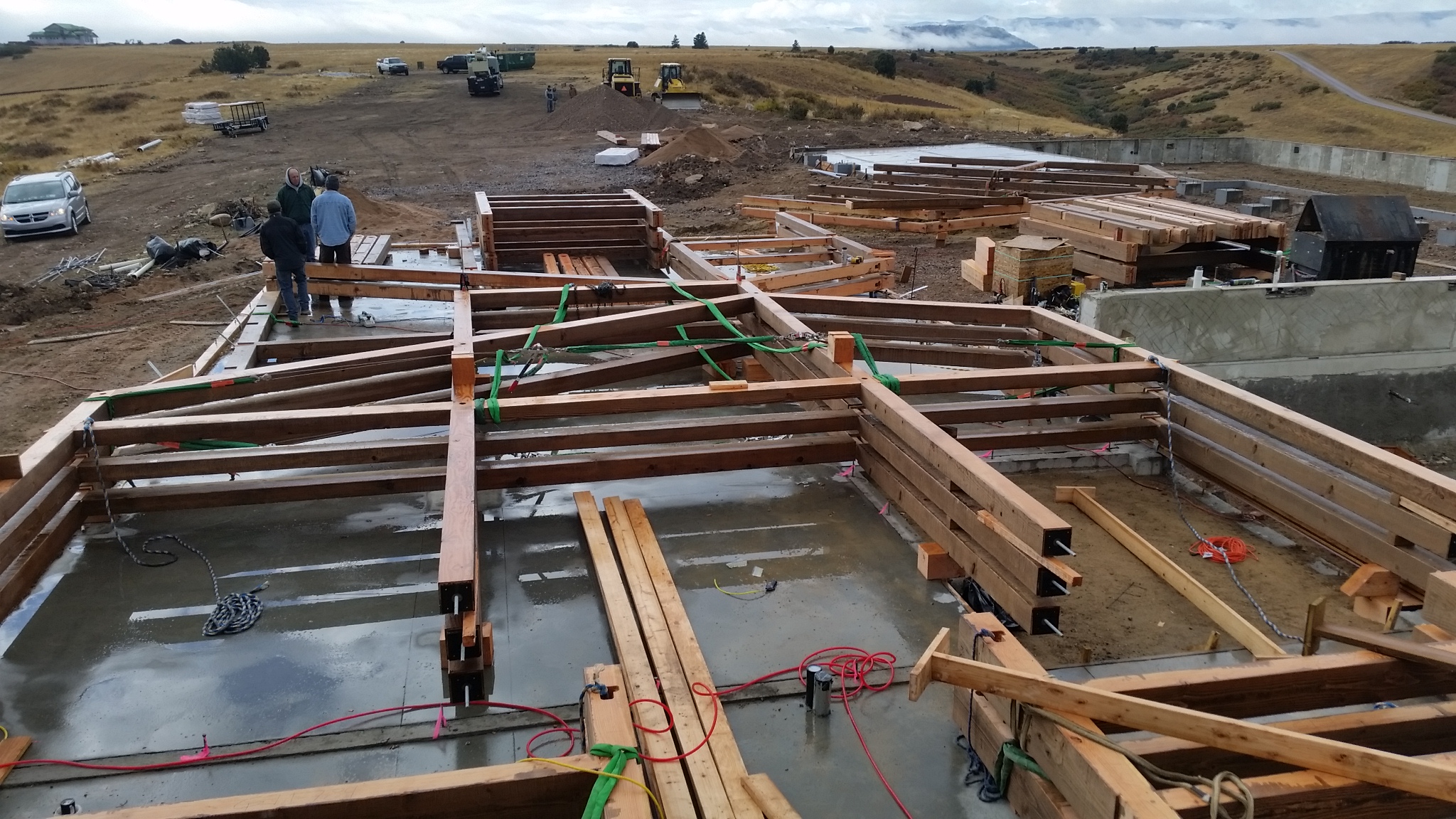 The pre-assembled bents sitting on the barn foundation give a sense of just how large the structure will be once raised.