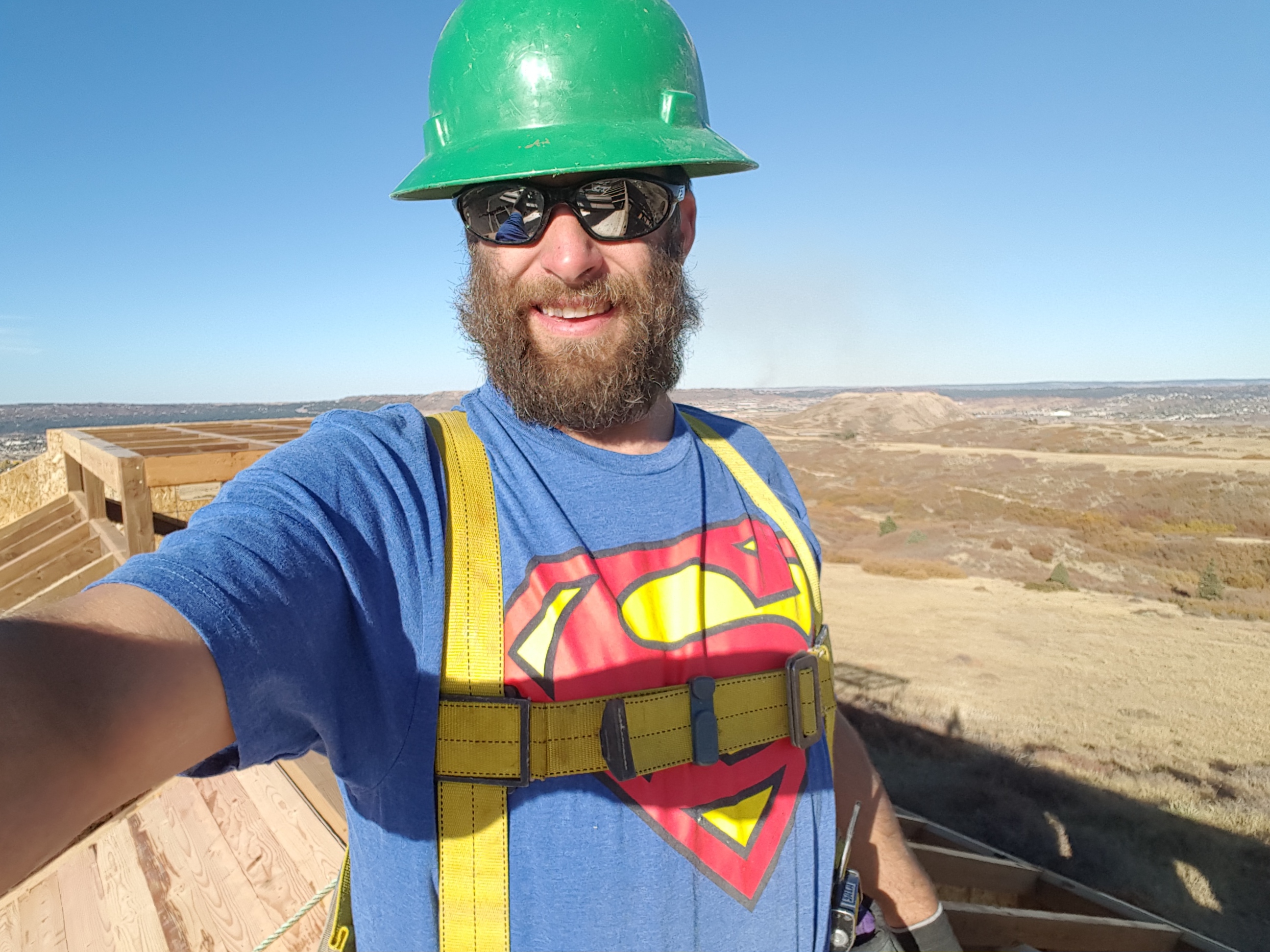 Mike models a Superman t-shirt, a fun gift from a vendor, while installing t&g on the barn roof.