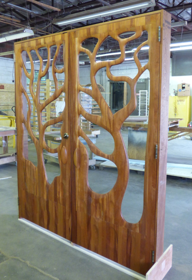 To create this “tree door”, the CNC first hulled out and surfaced the majority of the door. Our door team, lead by Jay, worked the rough output by hand/hand-held machine back to what we see as the final product. As Jay told us, “Many hands, many touches, many hours. One of the most customized pieces to date.”
