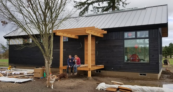 Phil and Rocio along with pups Luca and Sherlock enjoy a moment on the porch of their nearly completed NEW Jewel.
