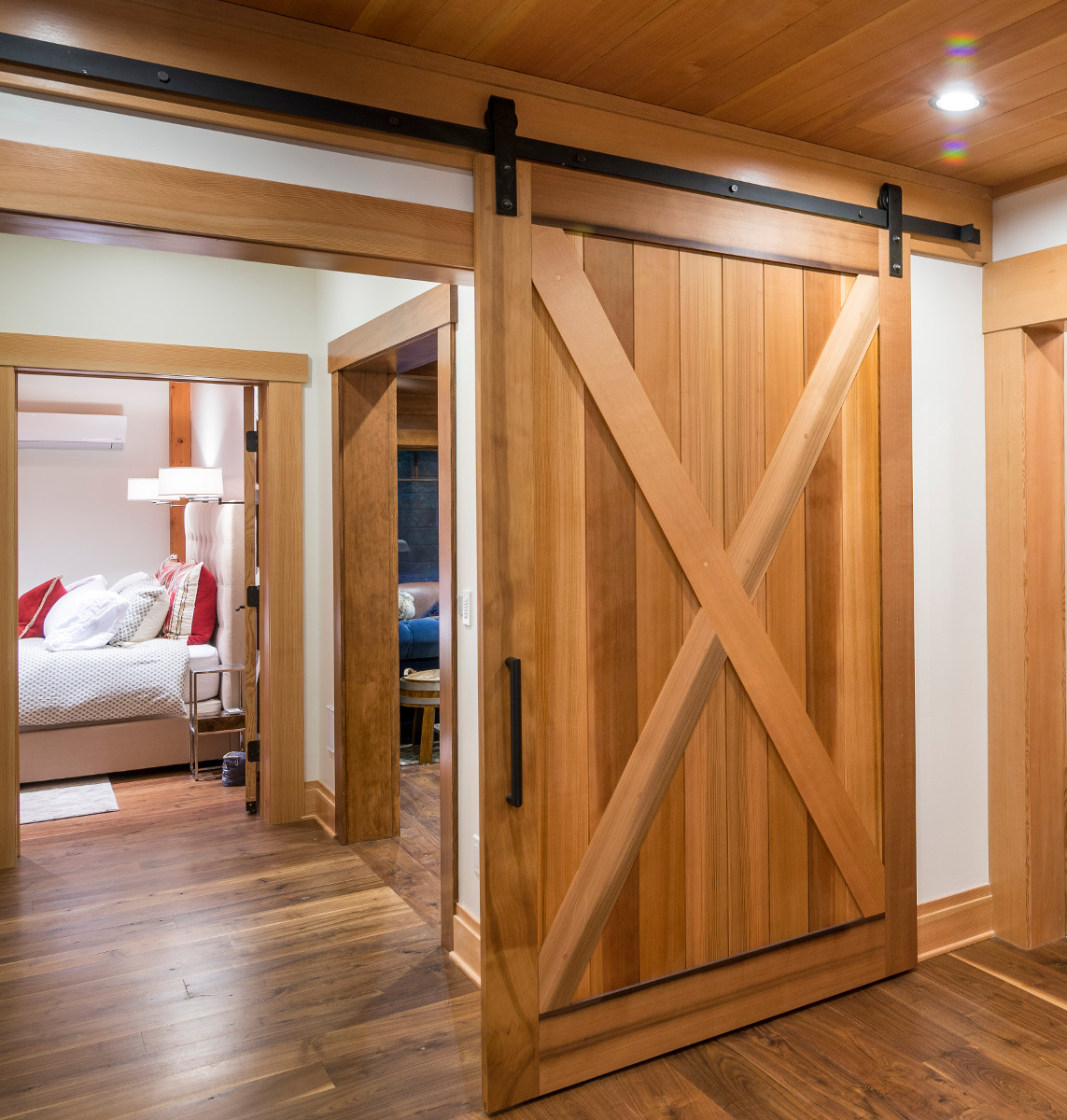 Flat tracks are top hung systems employing a top rail or mounted track above the door opening. A pair of hangers are assembled to the specific door (thickness, width, and weight of the door are all considered). A second bottom track/rail, subtle bottom guide fins, or cradle fins are employed to help maintain the door’s vertical alignment with the wall.
