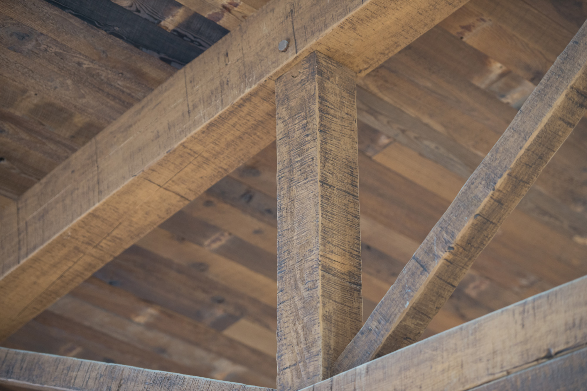 A custom finish with added texture visually unites the glulam top chord with the solid Douglas fir components in these bowstring-inspired trusses.