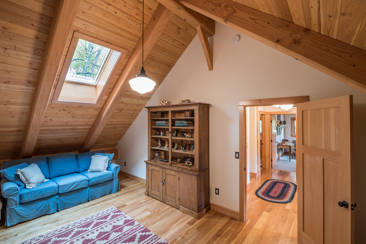 The timber frame loft offers more secluded space and continues the celebration of the couple’s sentimental antiques. Photo (c) Scott Hemenway