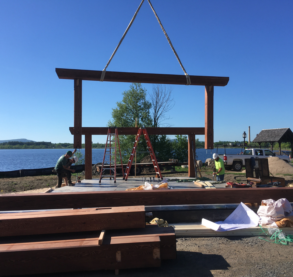 Pete and Jake (left) guide a post as the crane lowers the second timber bent into place. Rick (right) readies another post base fastener.