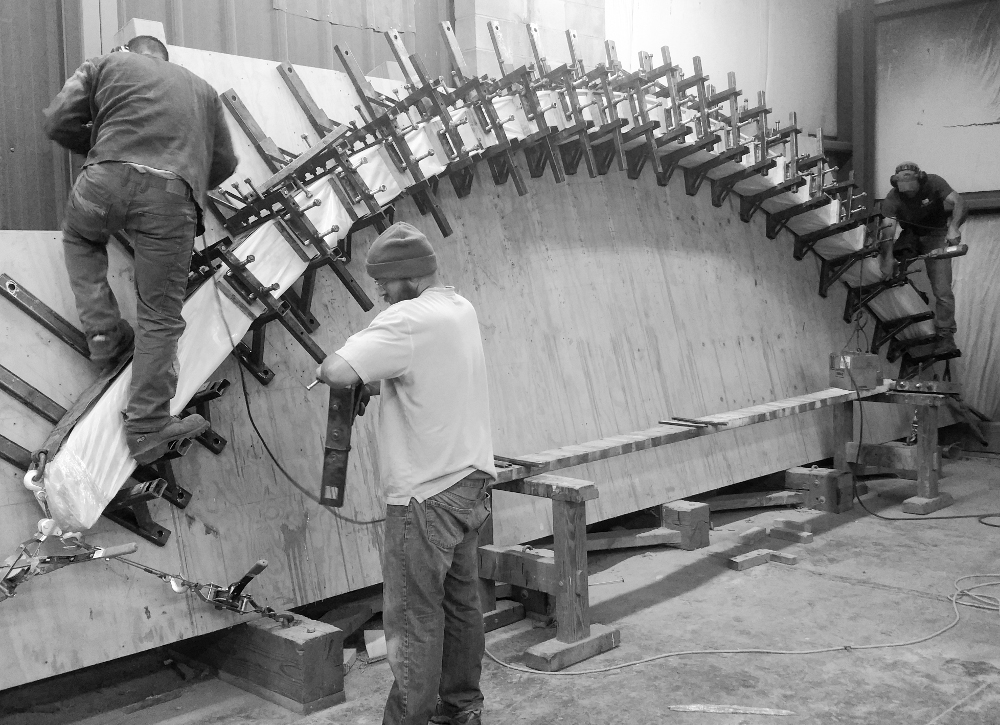 Our timber framers crafted the grain matched curves from single timbers, sliced to malleable layers, affixed to one another and shaped on the rack.