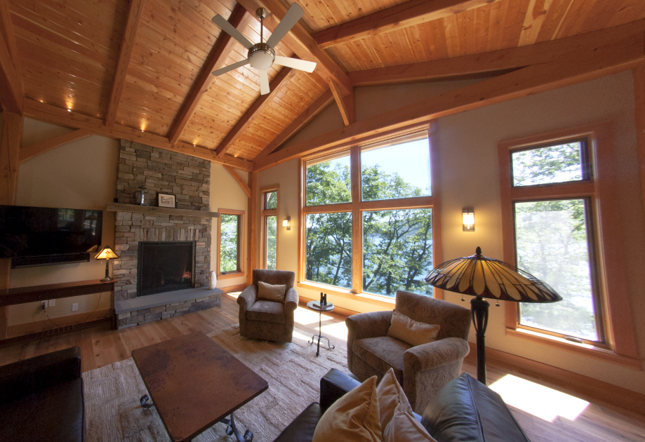 Inside the home, the great room offers intimate volumes while capturing views of the trees and lake outside.