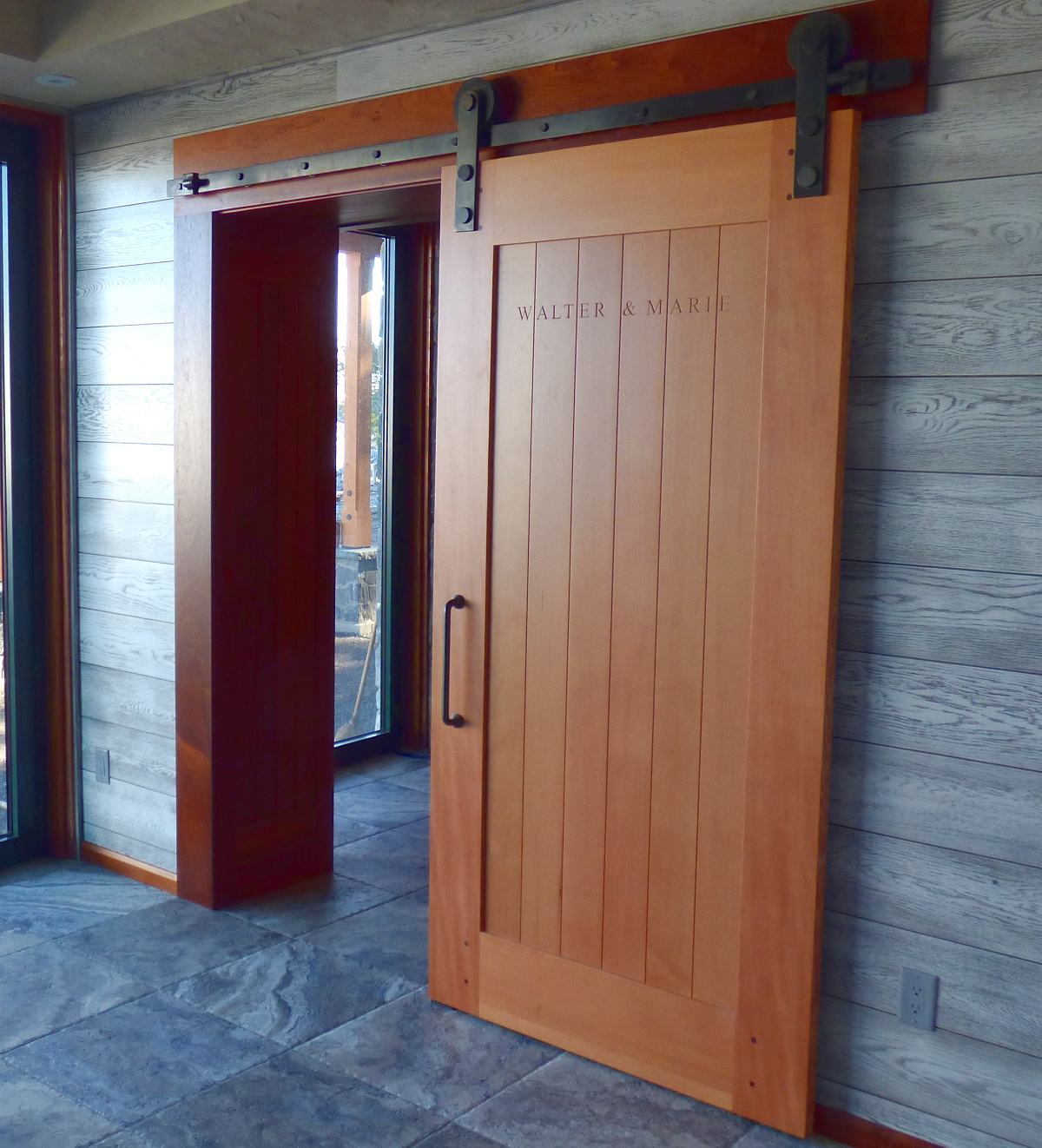 Clean lines and the warm tones of a custom Douglas fir sliding door contrast with the surrounding cool-toned materials.