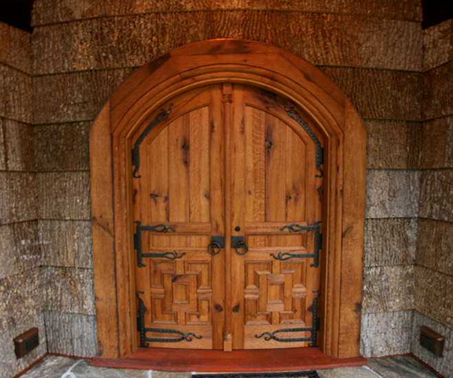 Crafted of reclaimed oak, these custom chapel doors are both arched and curved to match the curving exterior wall.