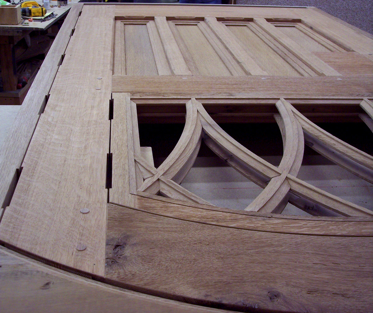 Our fine woodworkers are up for a challenge! These 3″ thick, arched doors crafted from brushed reclaimed Oak (shown here in process) for a Great Camp include the extra challenge of hinged gothic arched windows.