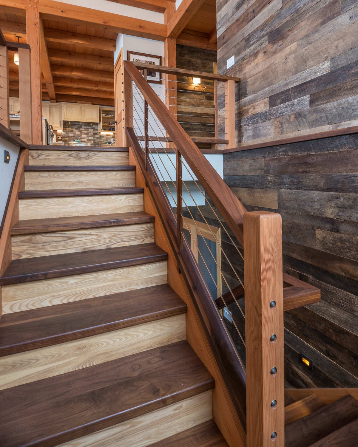 Woods used throughout this Hudson Valley home coalesce in the main stair where the railing/cables mimic the railing found on the outdoor deck (image below). Photo by Scott Hemenway.