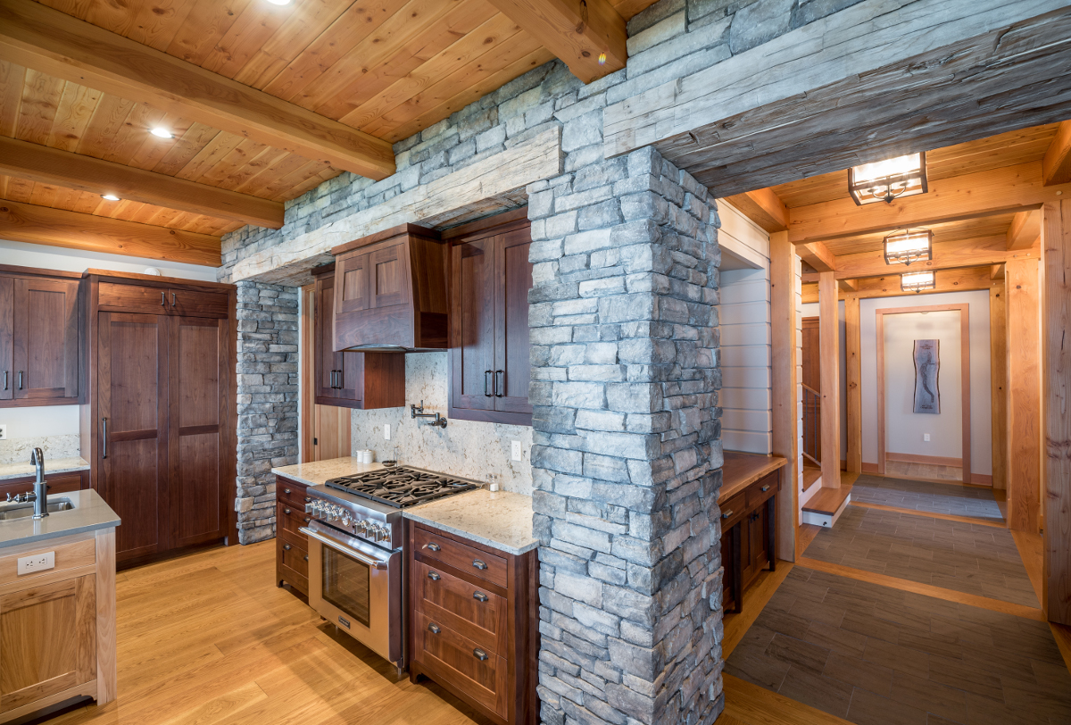 A substantial 24” reclaimed timber header within the stone defines the transition from away spaces into the entertainment areas. Photo (c) Scott Hemenway.
