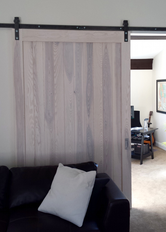 Custom white finish for an interior flat track door aligns with the overall interior decor.