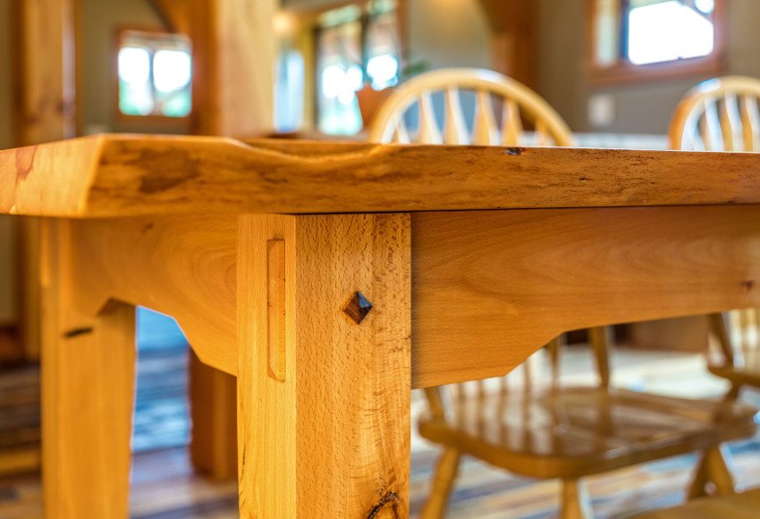 In the details: A reclaimed beech table with live edge, thru-tenon aprons, and walnut pyramid pegs.
