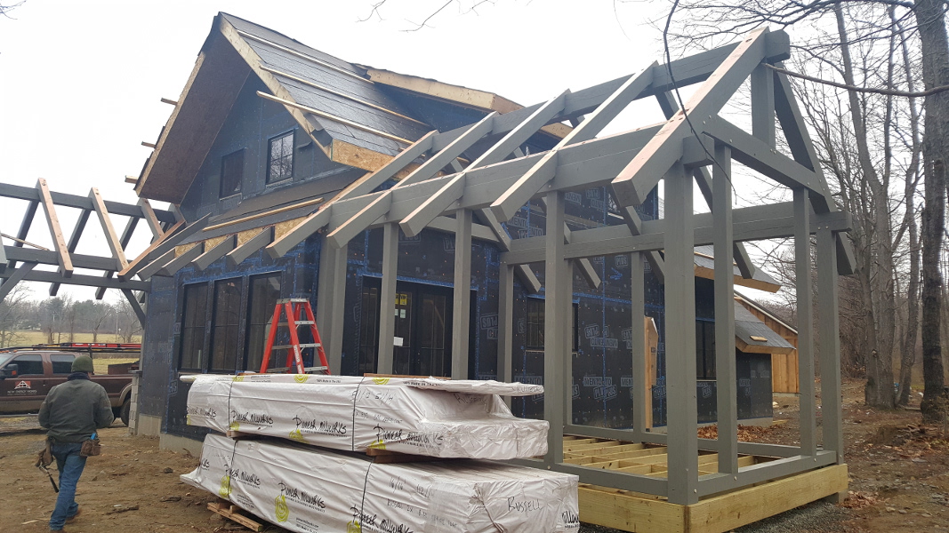 After the high performance enclosure was in place, our timber frame team returned to raise the exterior porch frames and accent pieces, all custom finished to a subtle earth tone.