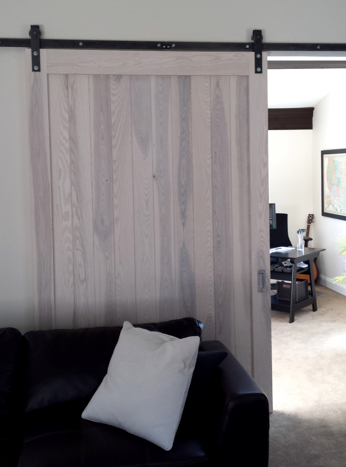 Gracefully sliding behind the couch in a living room, this door was also finished in a subtle wash to allow it to better blend with the surrounding walls.