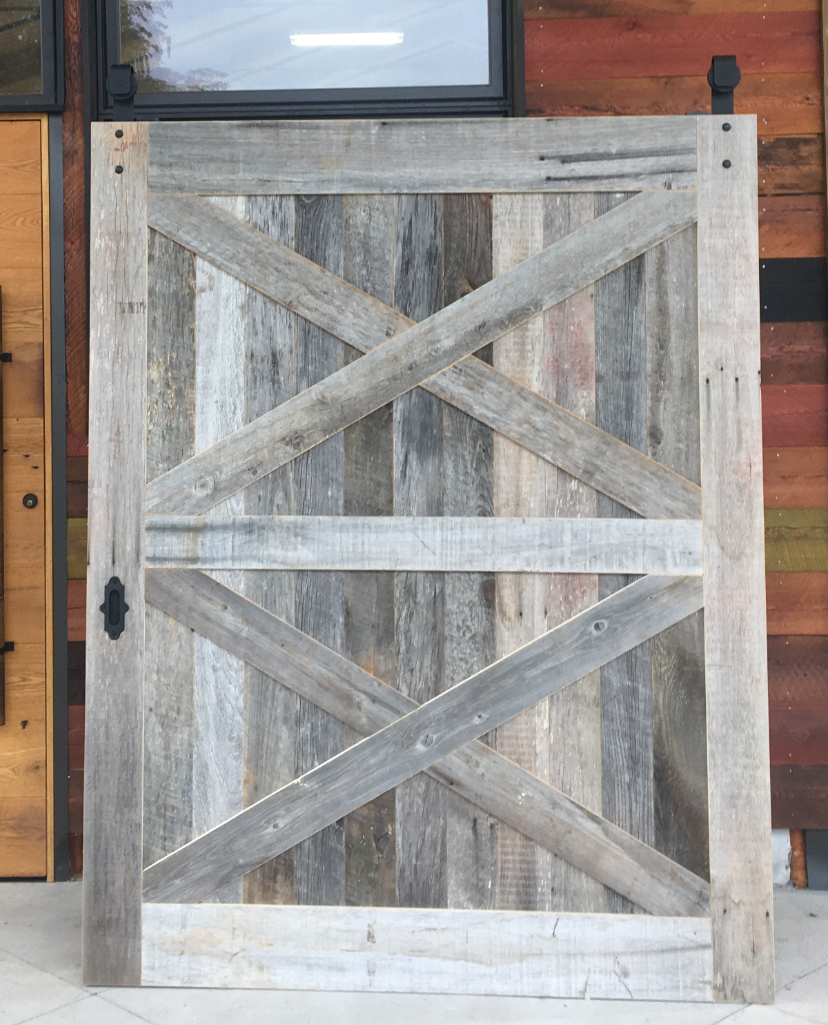 A wide double X flat track door crafted of Pioneer Millworks reclaimed American Prairie mixed softwoods.