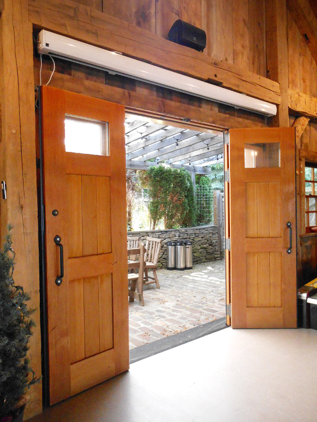 Custom folding doors open to access an expansive stone patio where many parties and gatherings take place.