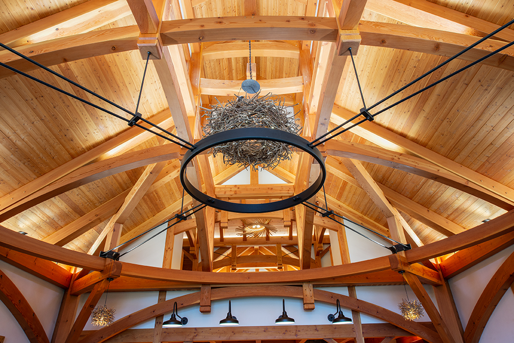 The resulting 36’ x 36’ great room is characterized by its “circle in a square” timber frame that is the core to the overall basket-like structure.