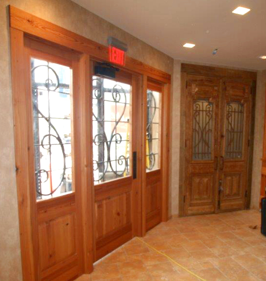 Inspired by the adjacent antique doors, the new main entry door for the eatery entrance was crafted of Reclaimed Heart Pine by NEWwoodworks.
