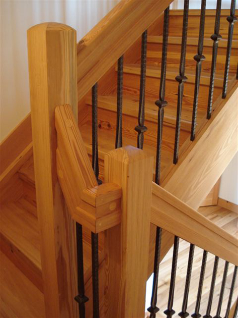A reclaimed Heart Pine stair with a solid rail including handcrafted returns.