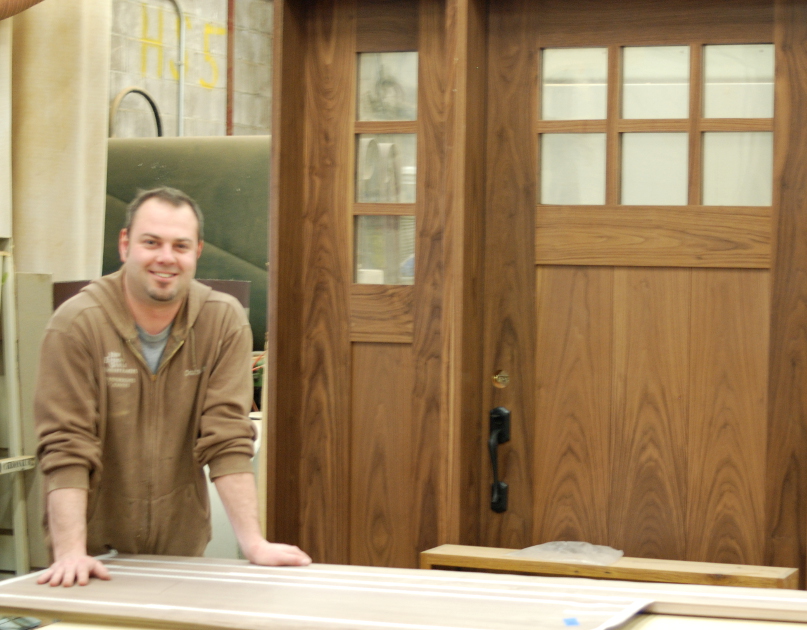 Jay Bernard, door guru at NEWwoodworks, pictured with a completed walnut entry door and sidelight.