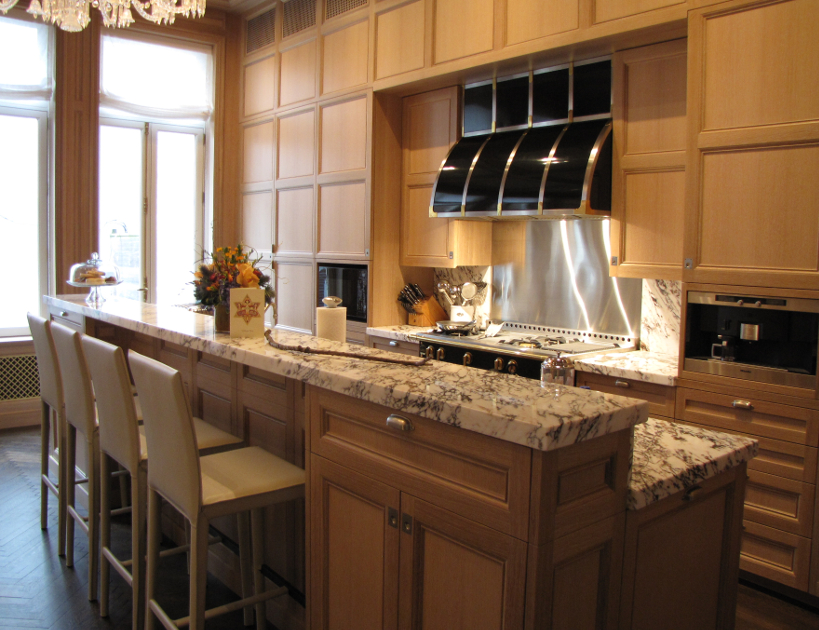 The repeating squares, subtle hardware, and light wood tones with crisp grain lines bring tranquility to this loft kitchen.