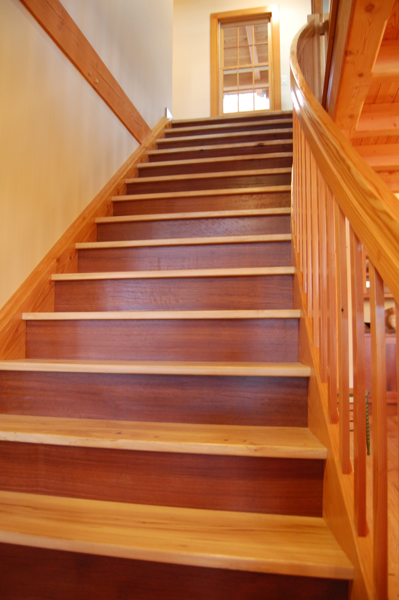 A combination of reclaimed Jarrah risers, reclaimed Elm treads, and Douglas fir balusters/railing from the gently curving stair which unites the upper street level private spaces and main level public spaces. The flair of the stair welcomes one into the living room/kitchen/dining areas. This stair was crafted by our fine woodworking division, NEWwoodworks using reclaimed wood from Pioneer Millworks.