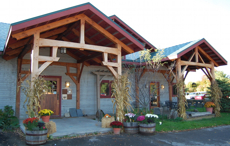Prior to re-finishing, the timber frame porches of our Farmington headquarters had lost much of their original protective oil finish and natural patina.