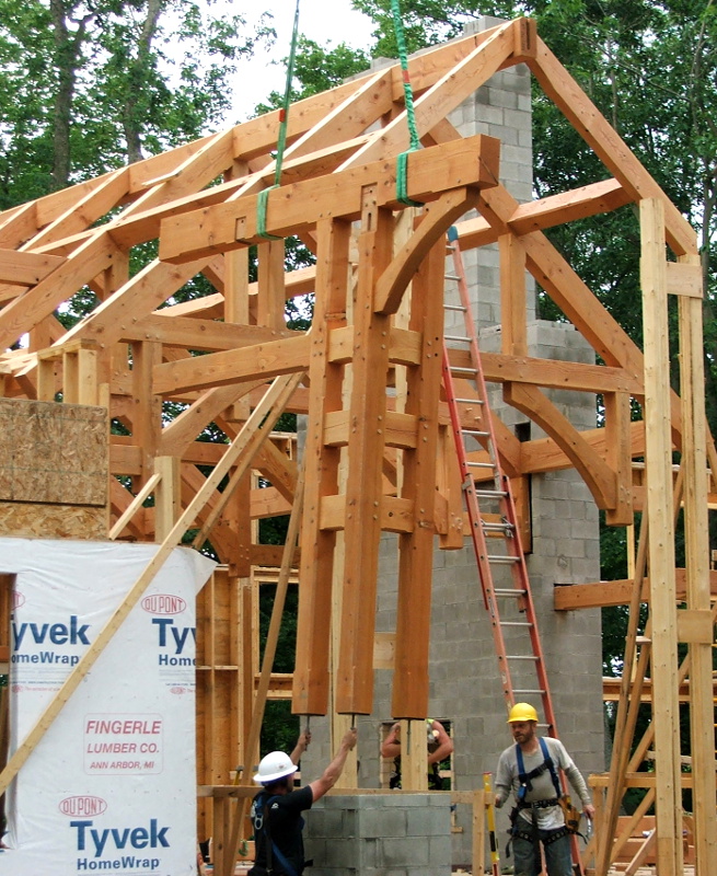 Guiding the corner posts of the entryway is an effort in communication on the ground and to the crane operator.