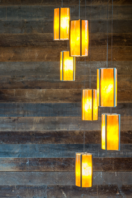A reclaimed wood paneling wall feature from Pioneer Millworks connects the two levels of the staircase.