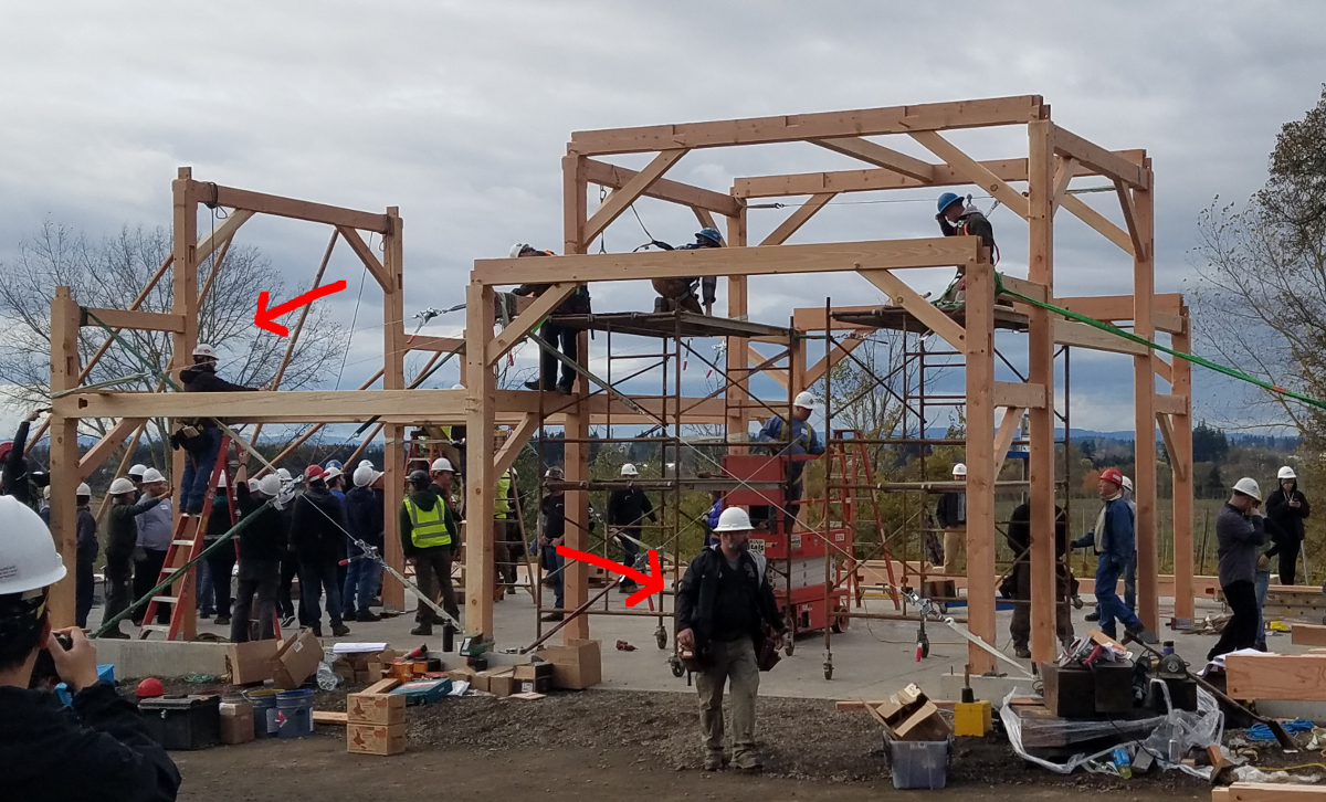 Sean (left arrow), project lead timber frame engineer, and Darren (right arrow), project timber frame champion, worked together as “Command Central” during the raising.