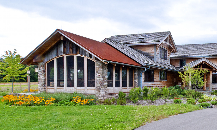 Porches are perfect spaces to combine elements. Reclaimed barn siding, stone, reclaimed timber, custom arched screens, and more. For a family in Mendon, New York, this porch is the place to be, day or night.