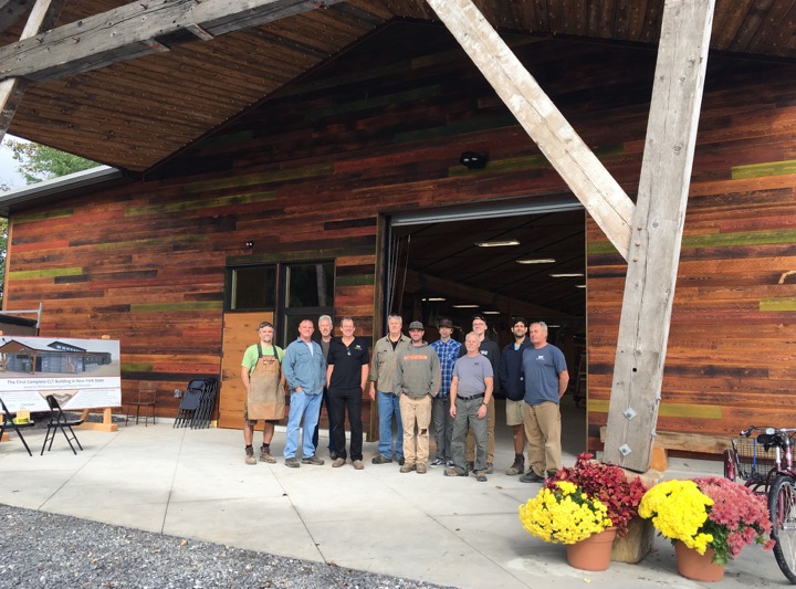 The NEWwoodworks team gathered at the entry to their CLT (Cross Laminated Timber) woodworking shop, the first of its kind in New York State.