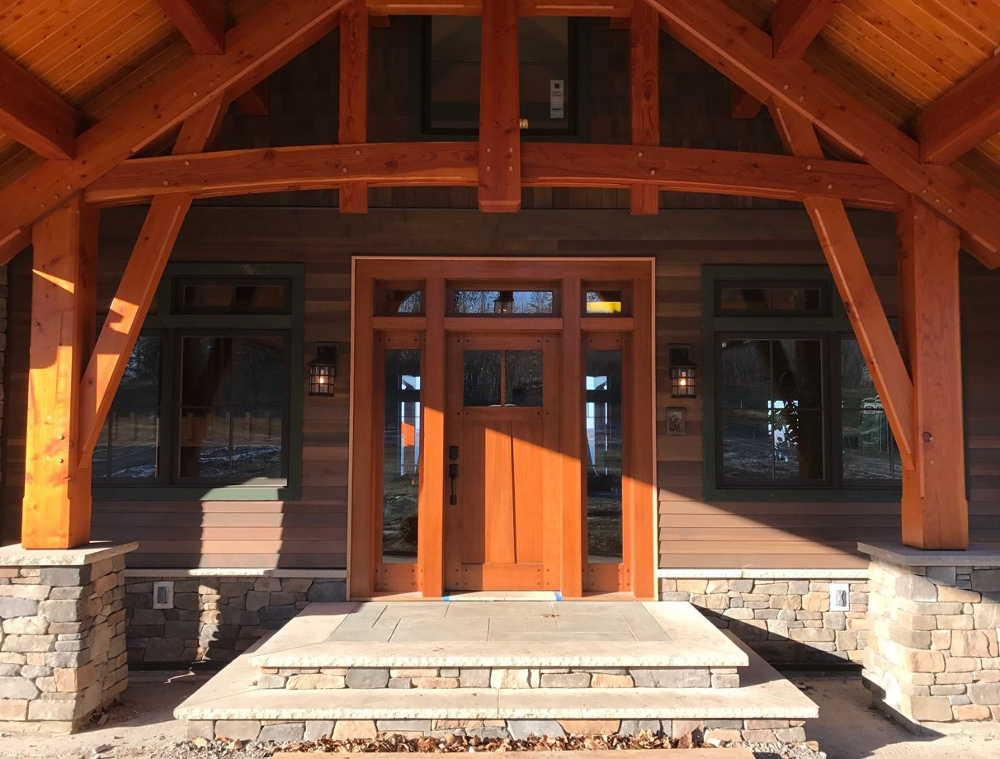 Under the new carport a custom door from NEWwoodworks welcomes guests.