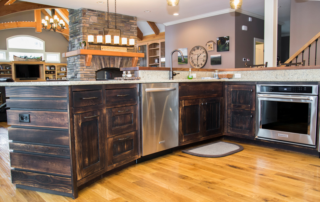 Broad, open views of the living and dining spaces are enjoyed from the cook’s vantage over the island of this lake home kitchen. Reclaimed oak was “toasted” to a darker patina adding a bit of rich color to an otherwise light palette.