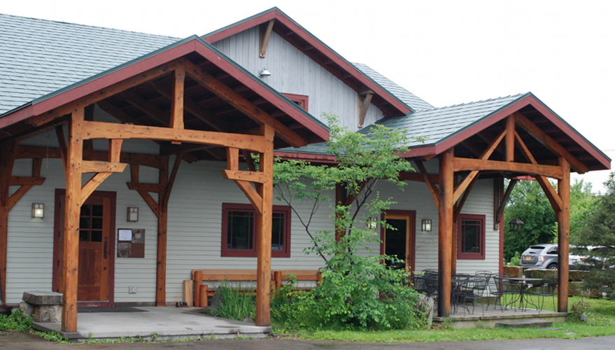 After re-finishing, the timber frame porches on New Energy Works celebrate renewed vitality along with the unique bolt holes, ferrous staining, and grain patterns inherent in reclaimed timber.